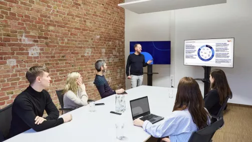 Foto von Mitarbeitenden, die an einem Konferenztisch sitzen und an einer Weiterbildung teilnehmen