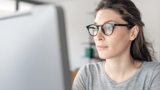 Bild einer Frau mit Brille am Computer